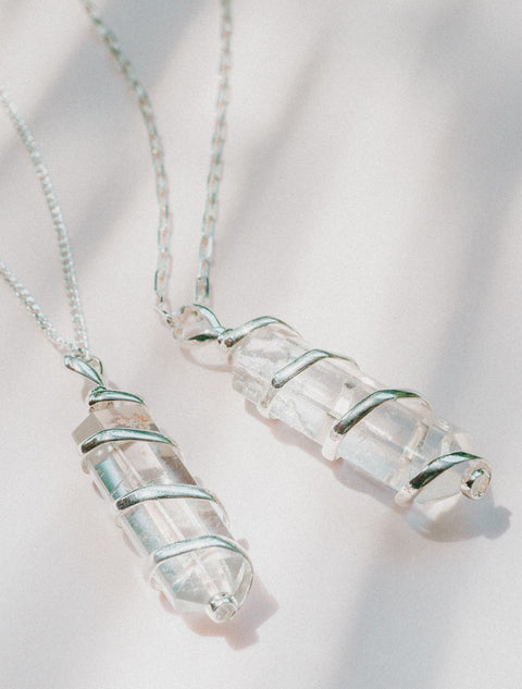 un couple de colliers en cristal posés sur une table