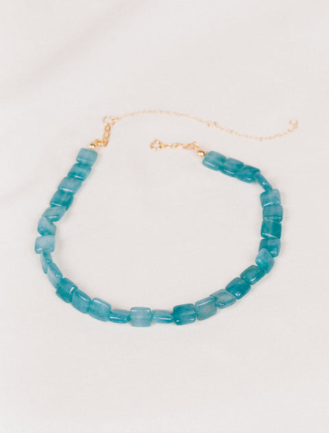 un collier en perles bleues avec une chaîne en or