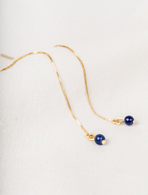 un collier avec une perle bleue et une chaîne en or