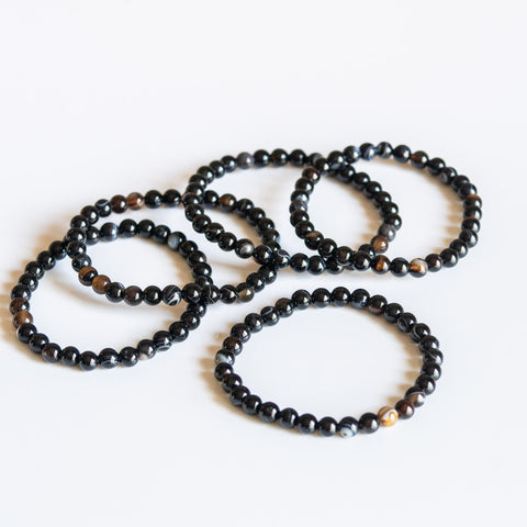 un ensemble de cinq bracelets avec des perles noires