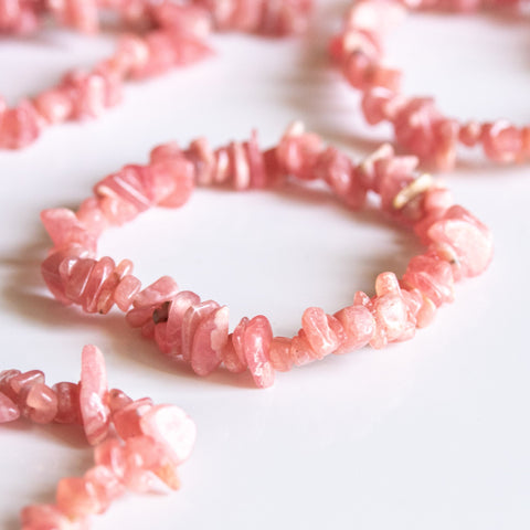 un groupe de perles roses sur une surface blanche