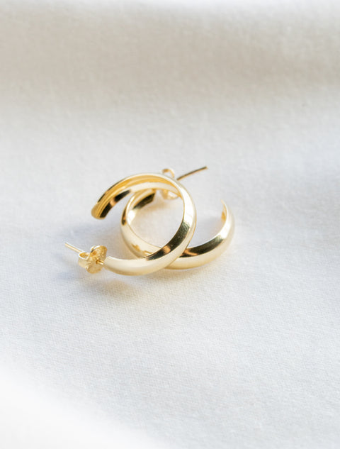 une paire de boucles d'oreilles en or sur un fond blanc
