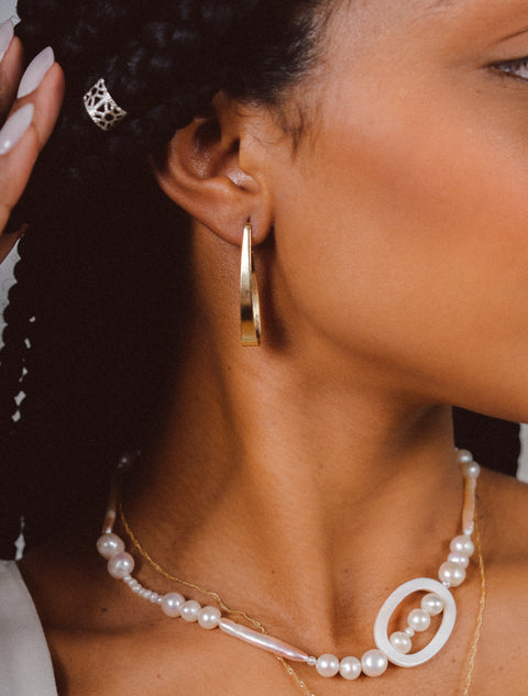 une femme portant un collier de perles et des boucles d'oreilles
