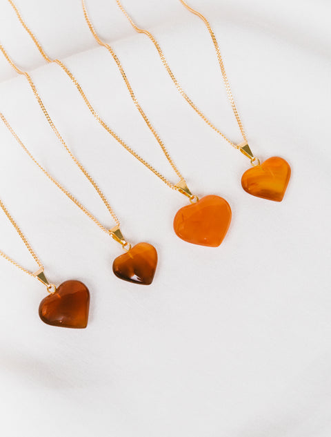 trois pendentifs en forme de cœur sur une chaîne en or