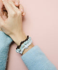 une personne portant un bracelet avec des perles autour de son poignet