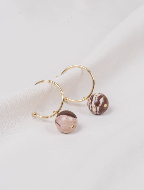 une paire de boucles d'oreilles en or avec des perles roses