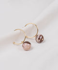 une paire de boucles d'oreilles en cercle doré avec des perles roses