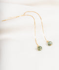 une paire de perles vertes suspendues à une chaîne en or