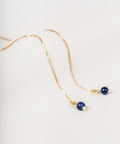 un collier avec une perle bleue et une chaîne en or