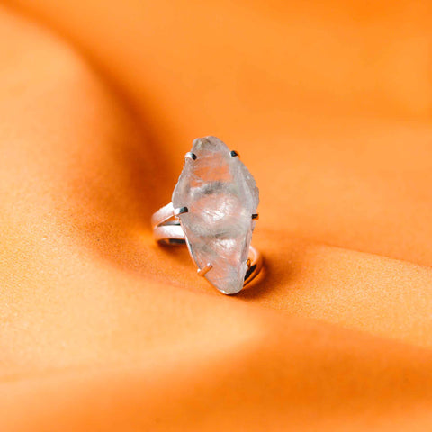 une bague en diamant posée sur un tissu orange