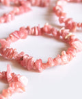 un groupe de perles roses sur une surface blanche