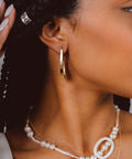 une femme portant un collier de perles et des boucles d'oreilles