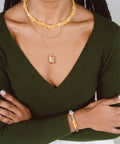 une femme portant une chemise verte et un collier jaune