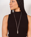 une femme portant un collier sautoir argenté en cristal de roche