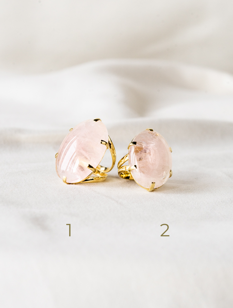 une paire de boucles d'oreilles roses posées sur un drap blanc